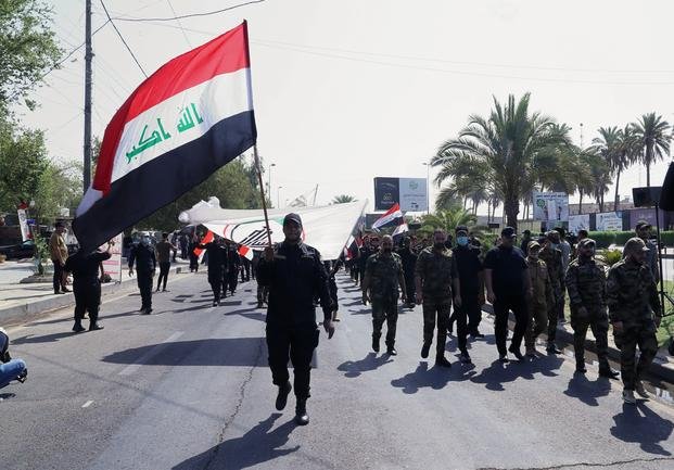 Iran-backed militia fighters march in central Baghdad, Iraq