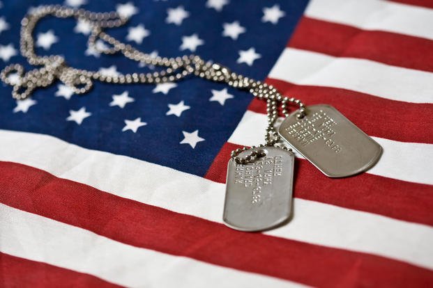 Dog tags sit on an American flag