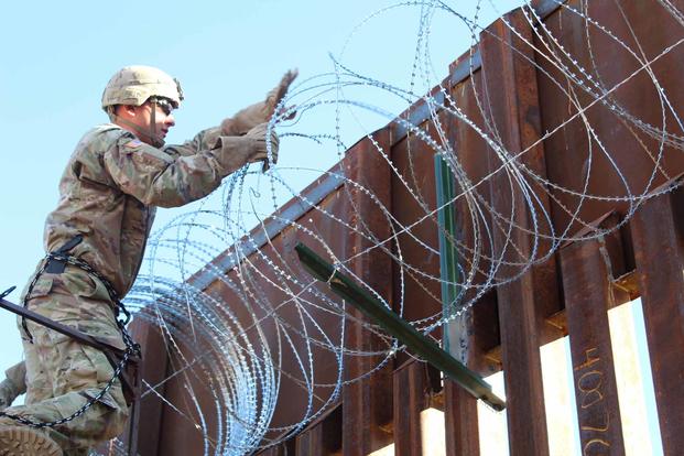 Soldier places concertina wire on the Arizona-Mexico border wall