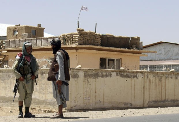 Taliban fighters stand guard inside the city of Ghazni