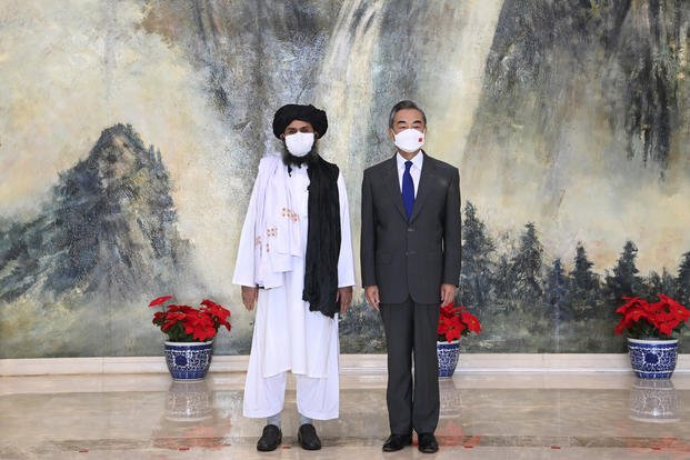 Taliban co-founder Mullah Abdul Ghani Baradar, left, and Chinese Foreign Minister Wang Yi 