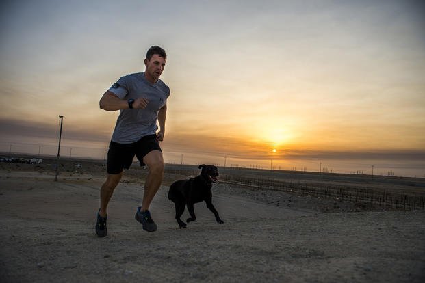 Air Force staff sergeant runs with dog.