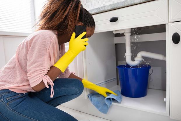 Woman attempting to repair kitchen sink