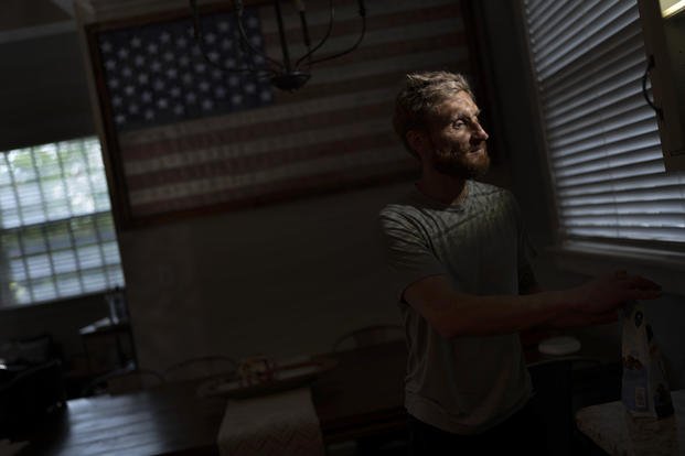 Brad Snyder in kitchen decorated with a flag handcrafted by Brooklyn firefighters