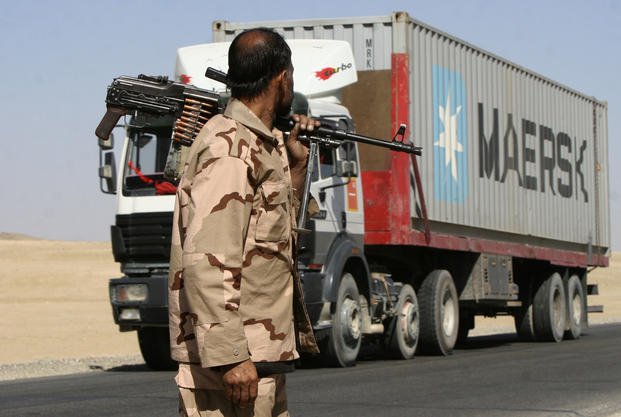 Private security contractor watches a NATO supply truck in Afghanistan