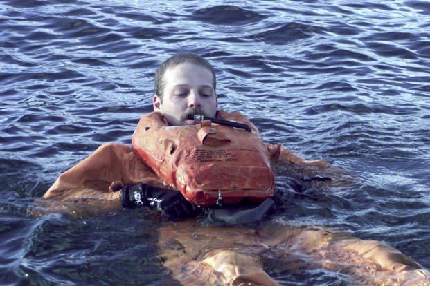 A Coast Guardsman swims in Alaska.