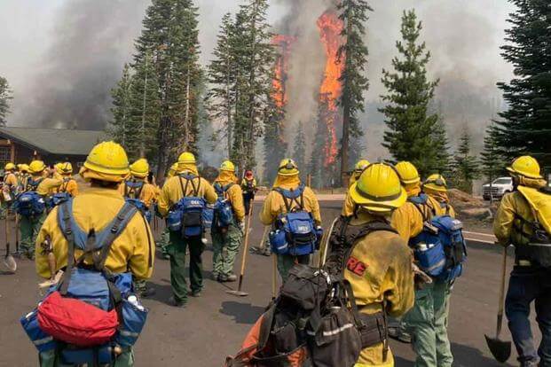 Trees burn within eyesight of a California National Guard hand crew