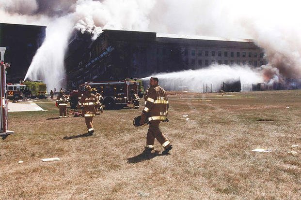 Fire crews work to put out the flames following the collapse of the E Ring, 11 September 2001.