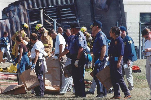 Volunteers and FBI personnel perform evidence sweeps near the point of impact, 11 September 2001. 