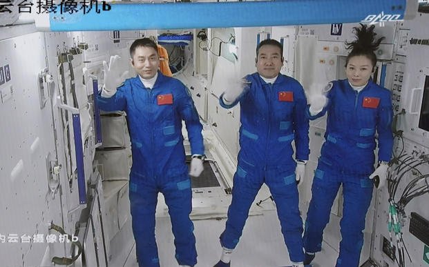 This screen image shows three Chinese astronauts.