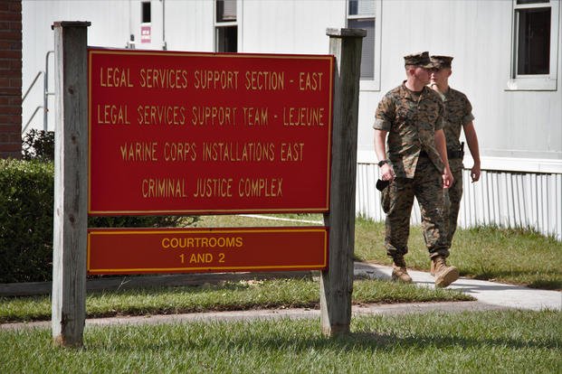 Two Marines walk past the sign outside the building where Lt. Col. Stu Scheller’s court-martial was being held on Thursday, Oct. 15, 2021. 