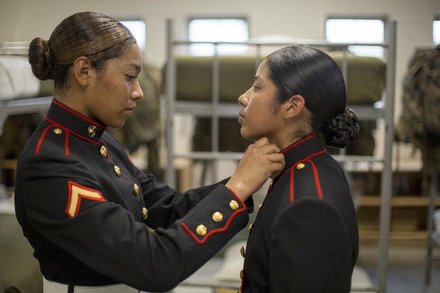 A female Marine undergoes a uniform inspection.