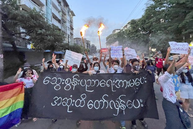 Protesters hold a banner written in Burmese. 