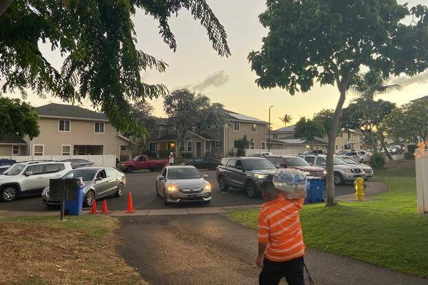Residents of military housing in Hawaii drive up to get donated bottled water 