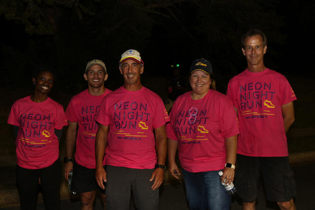 Fort Bragg staffers pose at the finish line of a nighttime run.