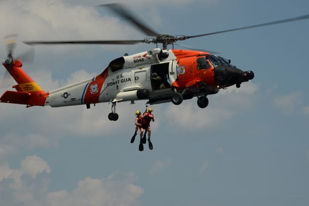 Coast Guard members demonstrate helicopter rescue training.