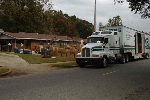 A moving truck is unloaded as a family moves into their new home