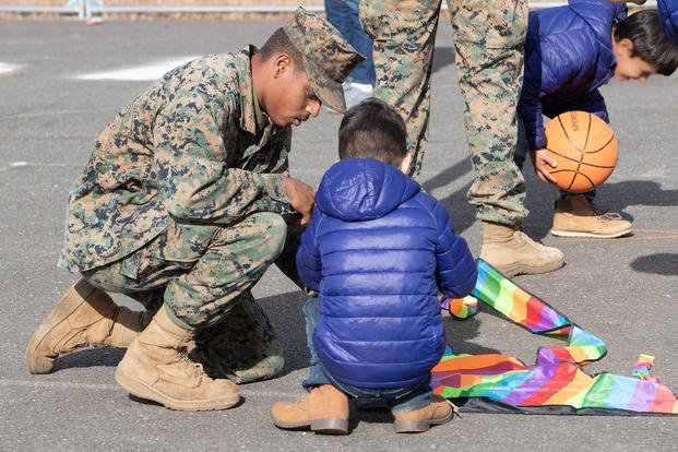 A Marine helps an Afghan refugee put together a kite for Thanksgiving at Marine Corps Base Quantico.