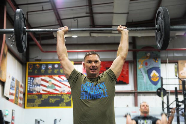 A soldier completes a thruster during a CrossFit competition.