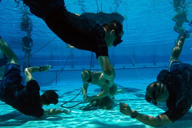 A Basic Crewman Training student demonstrates underwater knot tying.