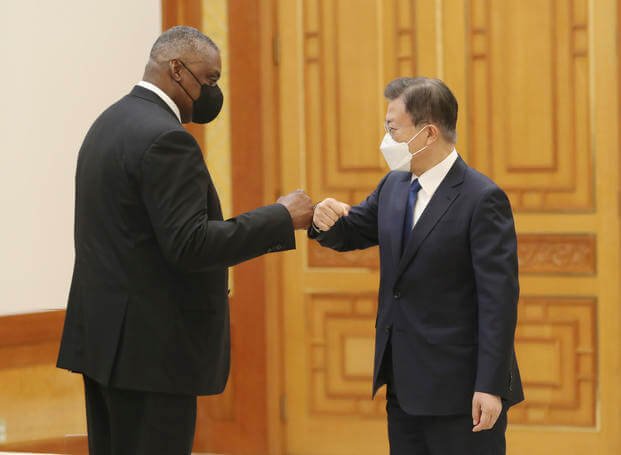 South Korean President Moon Jae-in, right, bumps elbows with U.S. Defense Secretary Lloyd Austin