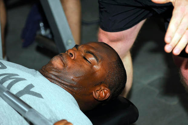 A soldier completes as many repetitions on the 225-pound bench press as possible.