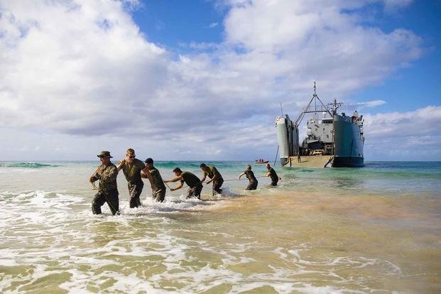 Marines pull a vehicle traction pad from an Army logistics support vessel during Spartan Fury at Marine Corps Base Hawaii.