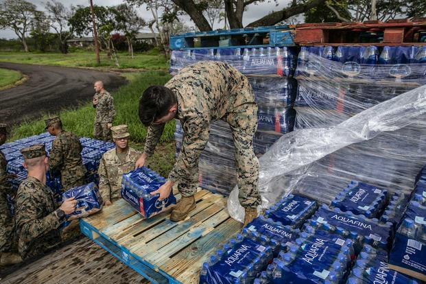 U.S. Marines and U.S. Army soldiers unload pallets of bottled water