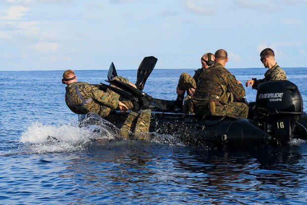 Marines exit their craft for a finned swim.
