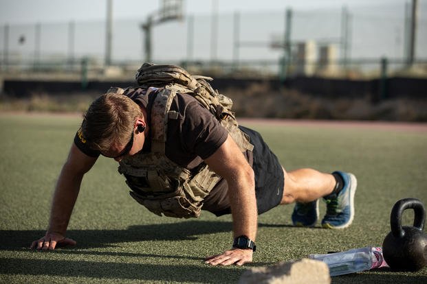 A member of Special Operations Joint Task Force-Operation Inherent Resolve, with his ballistic vest, is in the middle of completing the push-up portion of a workout.