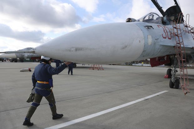 A Russian air force pilot walks to aSu-30 fighter jet 