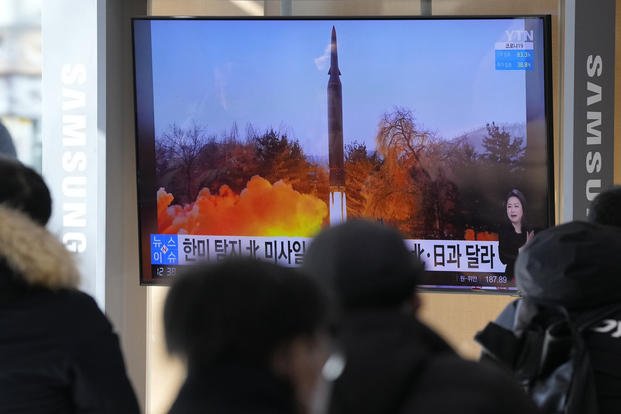 People watch a TV showing an image of North Korea's missile launch 