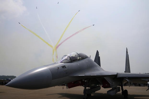 Fighter jets fly past a Chinese military's J-16D electronic warfare airplane