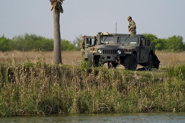 Members of the National Guard stand along the U.S.-Mexico border.