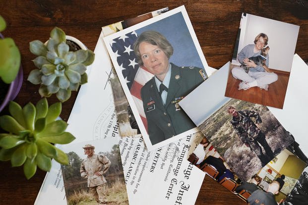 Photos of Julie Akey during her time at Ford Ord rest on a table in her home in Herndon, Va.