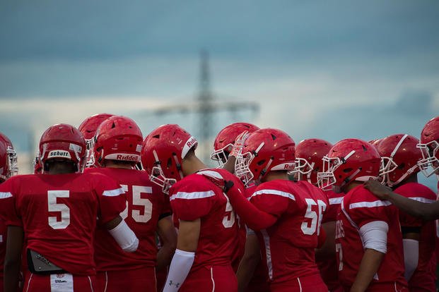 The Kaiserslautern High School Raiders huddle together before a game.