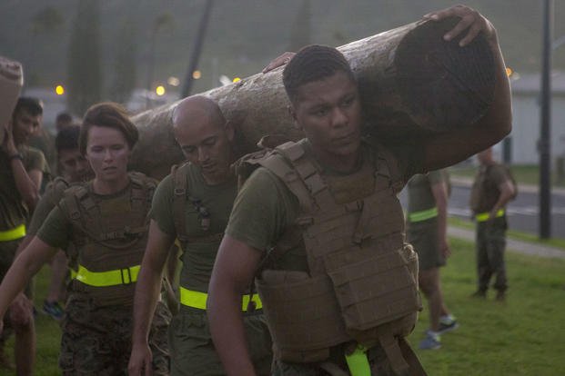 Marines carry a log during a battalion PT session.