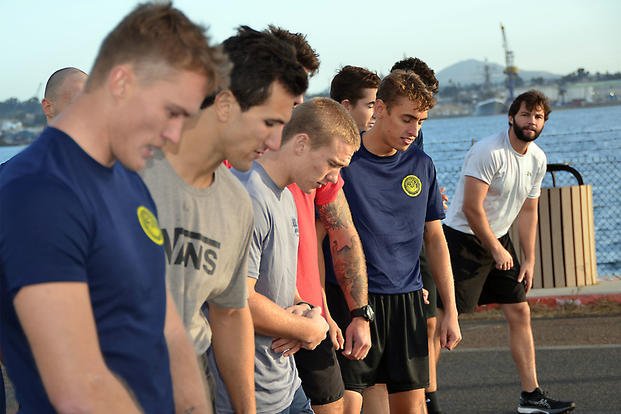 Future sailors line up before a timed 1.5-mile run during a physical screening test.