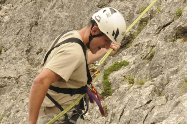 A U.S. Military Academy cadet, along with Italian soldiers, climbs a mountain.