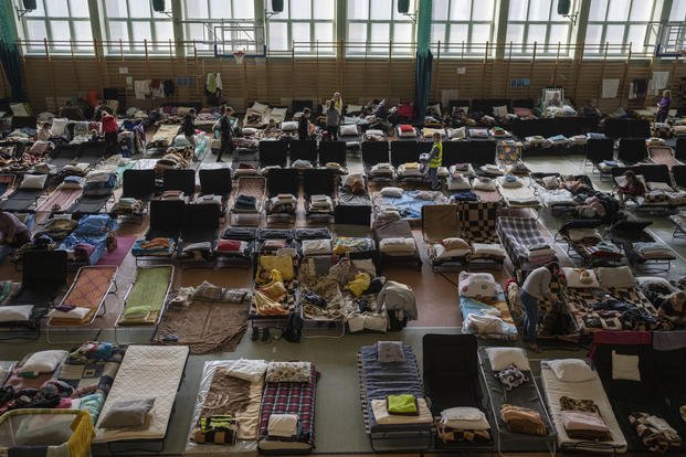 People who fled the war in Ukraine rest inside an indoor sports stadium in the village of Medyka.