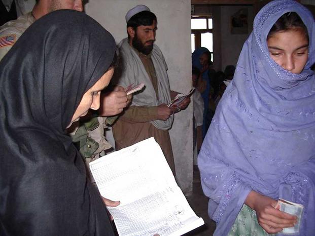 The Asadabad Civil Affairs team hands out money to Afghan women.