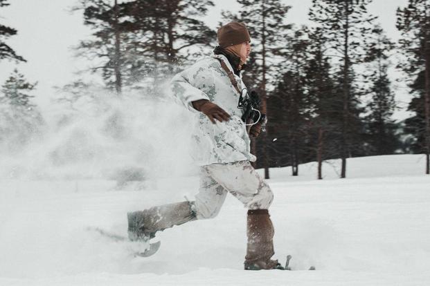 A U.S. Marine runs in snowshoes prior to Exercise Cold Response 2022.