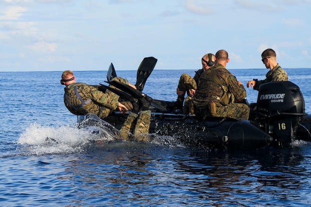 Marines exit a combat rubber raiding craft to conduct a finned swim.
