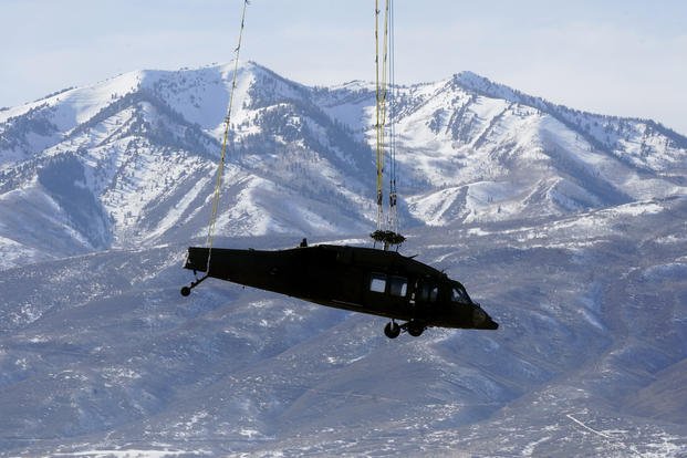 Army National Guard Black Hawk helicopter is transported by a National Guard CH-47 Chinook helicopter