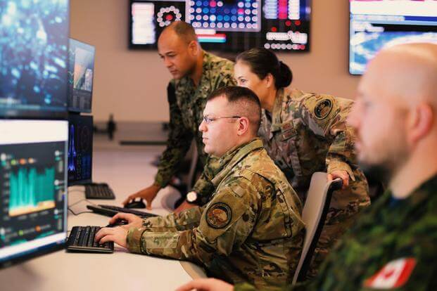 Multinational space operators work together in the Combined Space Operations Center in California. 