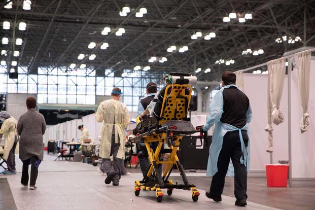 Service members transport a patient at the Javits New York Medical Station.