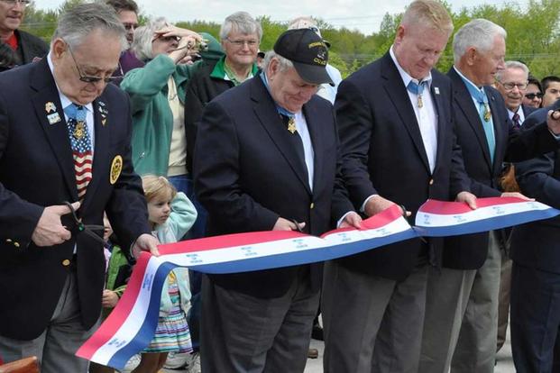 Kenneth E. Stumpf joins other MoH recipients in a ribbon cutting ceremony.