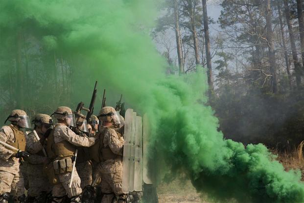 Marines use a smoke grenade during riot control training.