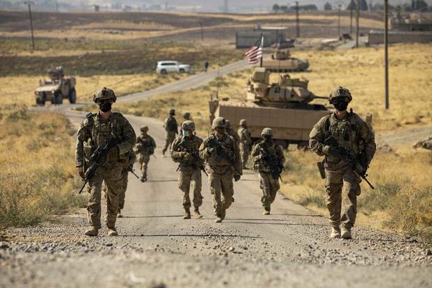 U.S. soldiers make their way to a oil production facility in Syria.