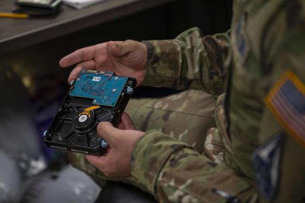 U.S. Space Force Guardian inspects a computer hard drive.
